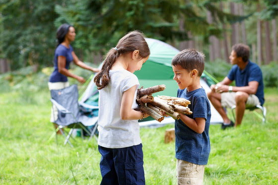 An image of one child passing firewood to another child.