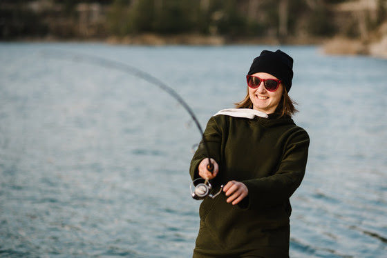 Woman fishing with rod, spinning reel