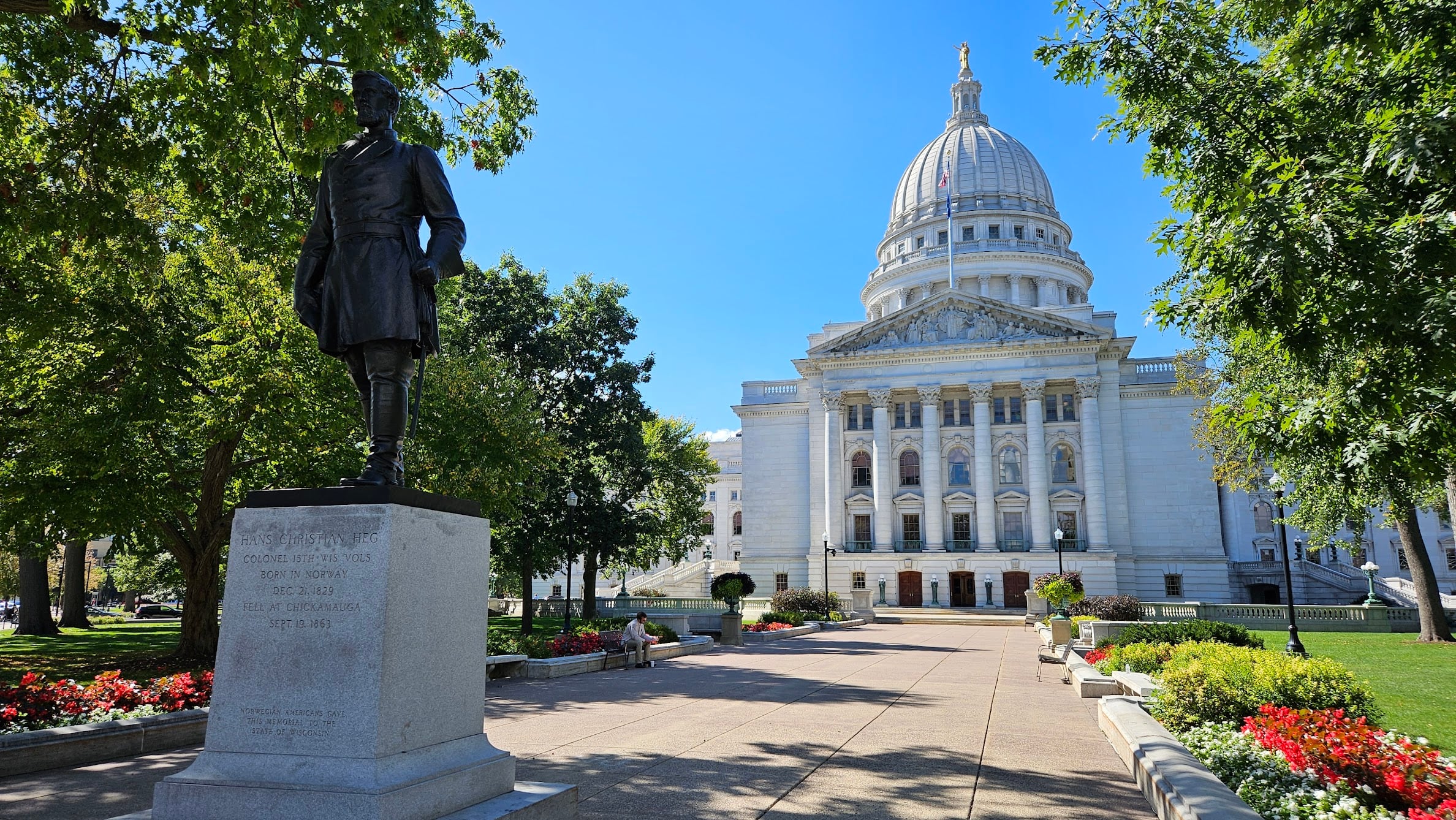 This picture shows a statue of Col. Hans Christian Heg in front of the Wisconsin Capitol on a clear day.