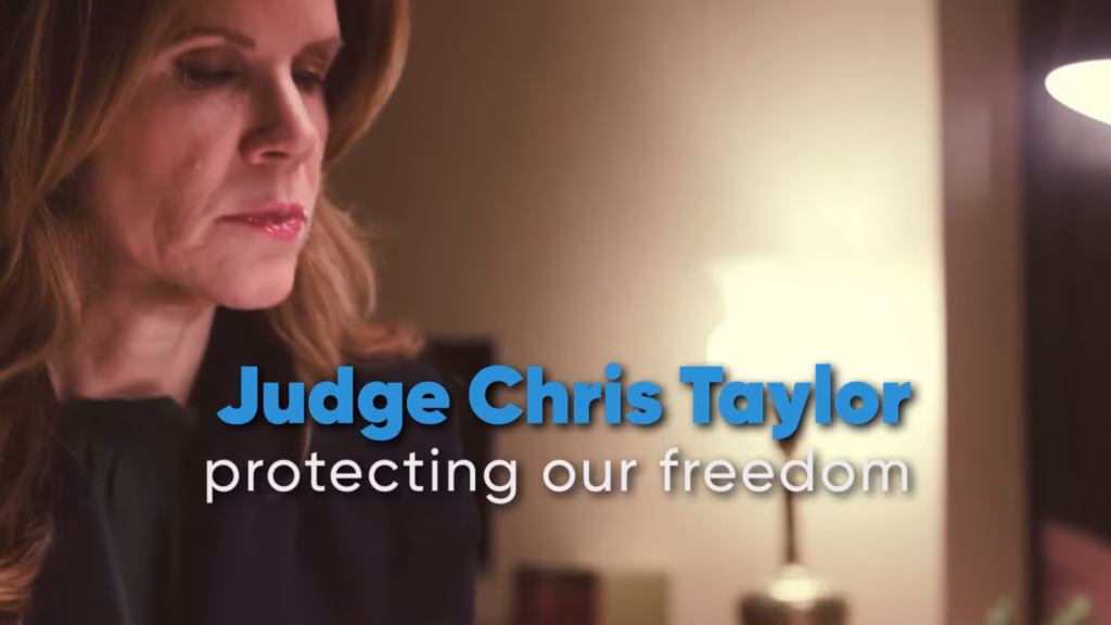 Screenshot from an ad by A Better Wisconsin Together Political Fund supporting Supreme Court candidate Judge Chris Taylor. The image shows a picture of Taylor, with text to the right of her name and "protecting our freedom."