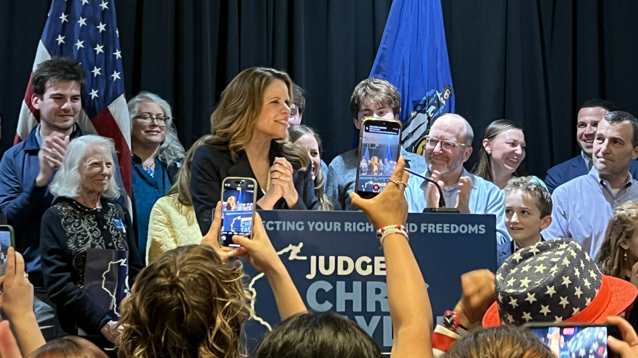 This image depicts Chris Taylor on a stage with supporters celebrating her victory in the state Supreme Court race.