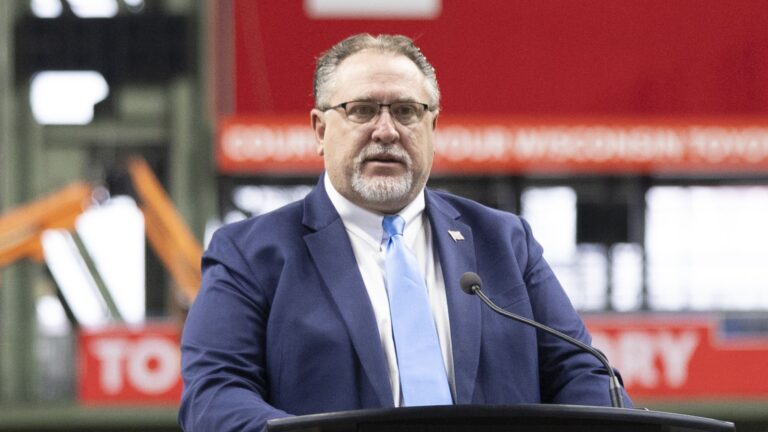 Photo of Rep. Rob Books at a podium at American Family Field in Milwaukee.