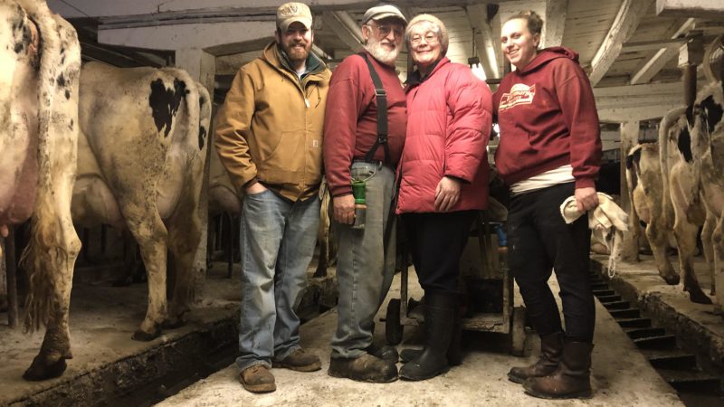 The Reisinger family in the dairy barn before the cows left. From left to right: son Brian, father Jim, mother Jean and daughter Malia. Image courtesy of Brian Reisinger.